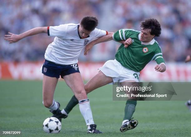 English footballer Chris Waddle is tackled for the ball by Scottish born footballer Ray Houghton during play in the group 2 match between England and...