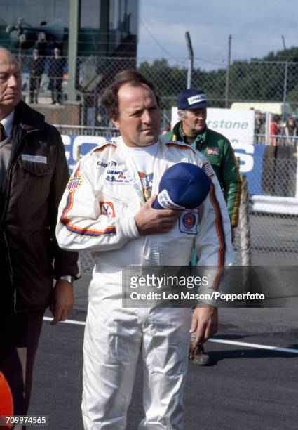 American racing driver AJ Foyt Junior holds his cap over his chest during action at the British Grand Prix at Silverstone, England circa 1977.