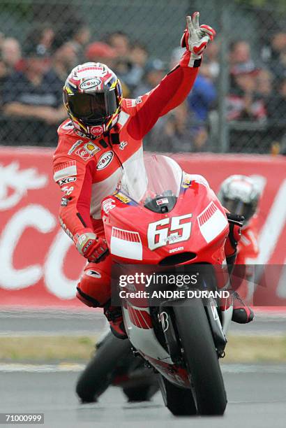 Italy's Honda driver Loris Capirossi celebrates as he crosses the finish line of the French MotoGP Grand Prix, 21 May 2006 at the Le Mans racetrack,...