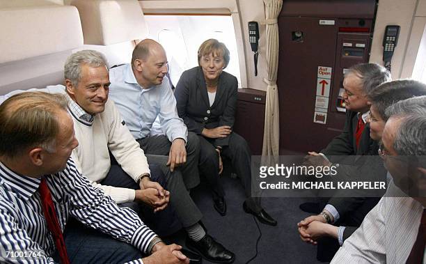 German chancellor Angela Merkel sits next to German Transport Minister Wolfgang Tiefensee and other members of her entourage as they fly to Beijing...