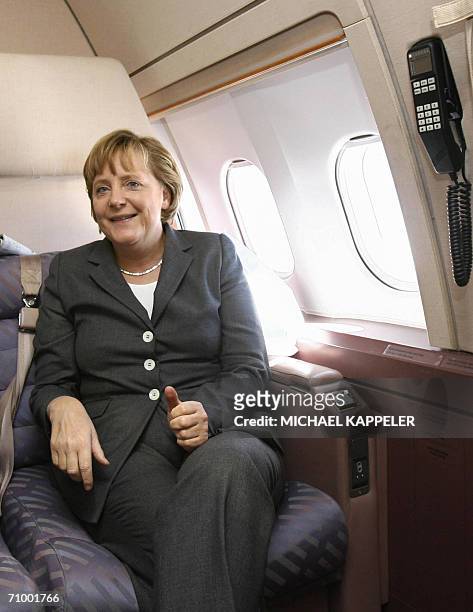 German chancellor Angela Merkel sits with members of her entourage as they fly to Beijing aboard the German aircraft Theodor Heuss, for an official...