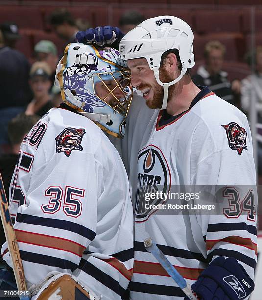 Fernando Pisani of the Edmonton Oilers congratulates teammate goaltender Dwayne Roloson on their win over the Mighty Ducks of Anaheim in game two of...