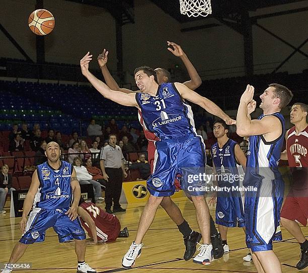 Chris Anderson of the Wellington Saints gets tackled by Taj McCullough of Winthrop University during an NBL Exhibition match between the Wellington...