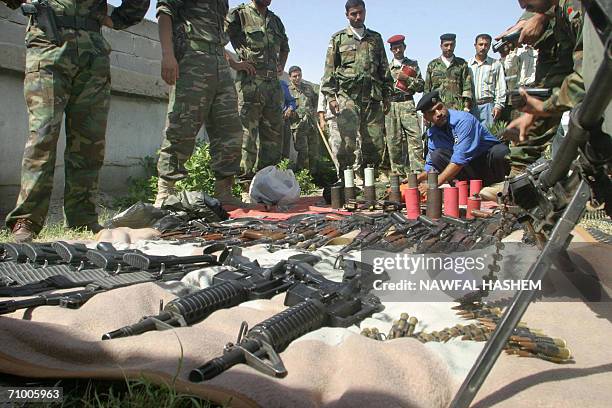 Iraqi policemen display confiscated weapons at a police station in the southern City of Basra 22 May 2006. Three Pakistani nationals were arrested by...