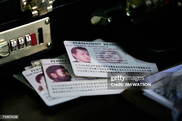 Alexandria, UNITED STATES: Permanent residence cards, known as green cards, rest on the check-in table as resident aliens arrive for a naturalization...