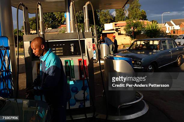 Petrol attendant fills a tank during rush hour at a Sasol station on February 7, 2006 in Soweto outside Johannesburg, South Africa. Sasol makes...