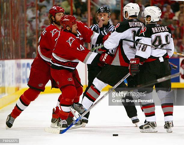 Mike Commodore and Kevyn Adams of the Carolina Hurricanes fight with J.P. Dumont and Daniel Briere of the Buffalo Sabres in game two of the Eastern...