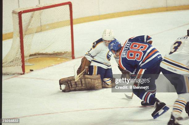 Wayne Gretzky of the Edmonton Oilers slips the puck past goalie Don Edwards of the Buffalo Sabres for his 77th goal of the season during their game...