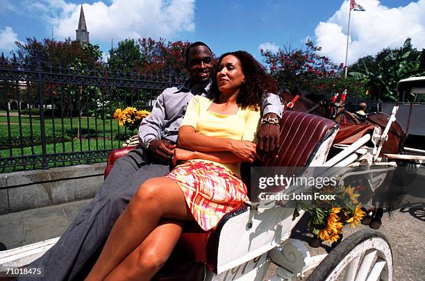 young couple sitting in carriage, smiling - st louis cathedral new orleans 個照片及圖片檔