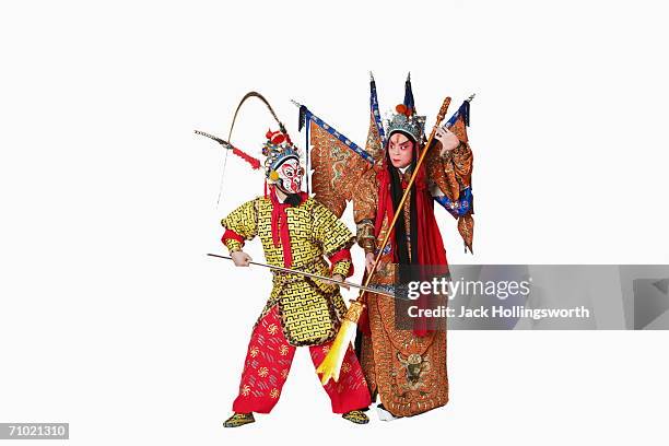 two male chinese opera performers gesturing with weapons - chinese opera makeup stock pictures, royalty-free photos & images