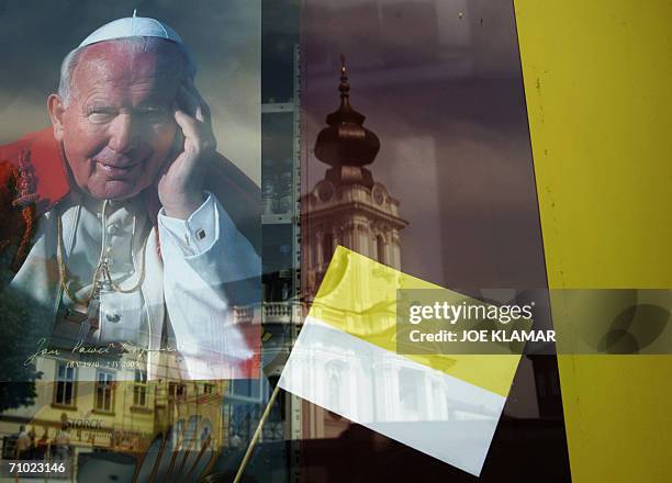 The Basilica of the Presentation of Virgin Mary church where late John Paul II was babtised is reflected on a shop window where a picture of the late...