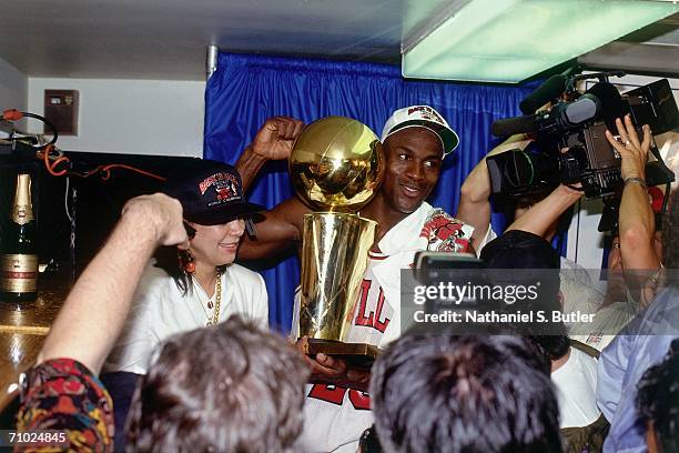 Michael Jordan of the Chicago Bulls celebrates with the Larry O'Brien trophy after defeating the Portland Trailblazers in Game six of the NBA Finals...