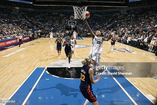 Seimone Augustus of the Minnesota Lynx goes for the layup against Katie Douglas of the Connecticut Sun on May 23, 2006 at the Target Center in...