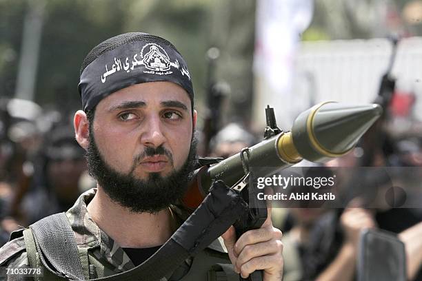 Militant from the Al-Aqsa Martyr's Brigade, a group linked to Palestinian President Mahmoud Abbas' Fatah Movement, holds a weapon as he participates...