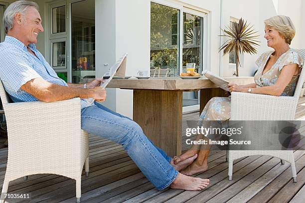 senior couple reading newspapers - playing footsie stock pictures, royalty-free photos & images