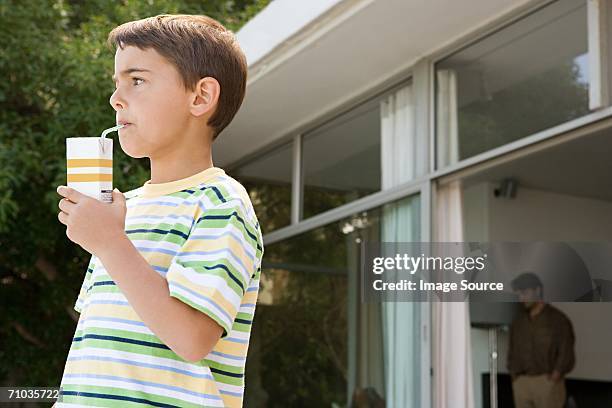 young boy 飲む、カートンのオレンジジュース - ジュースパック ストックフォトと画像
