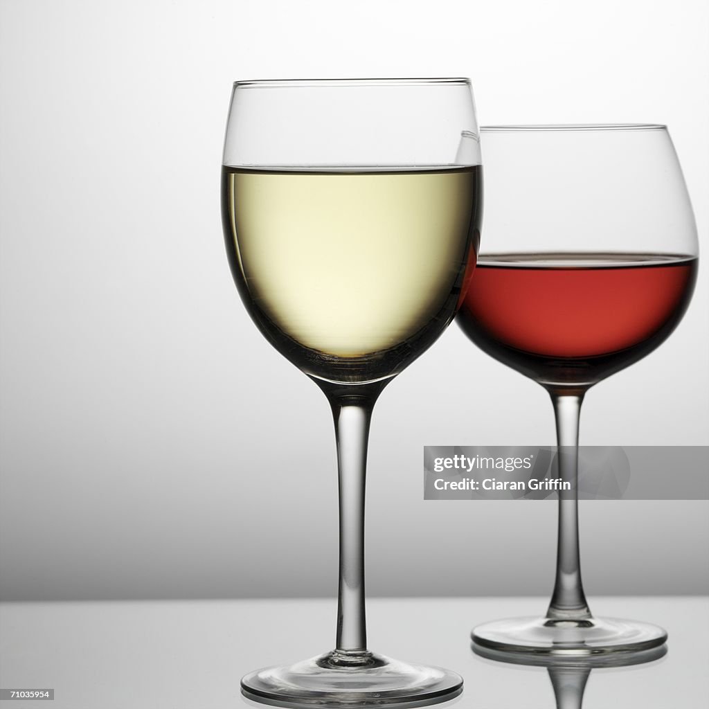 Close-up of a glass of white wine with a glass of red wine in the background