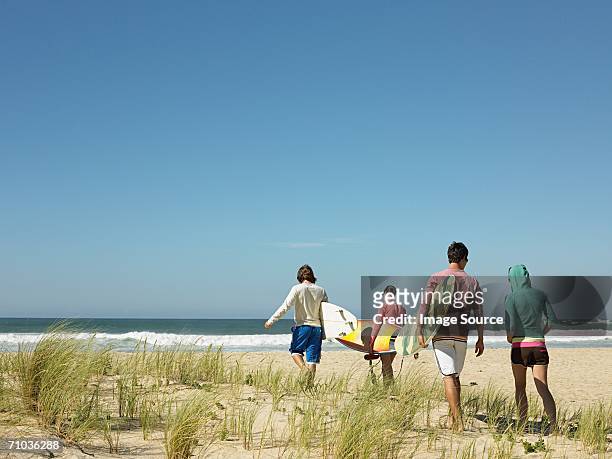 surfers heading to the sea - heading design stock pictures, royalty-free photos & images