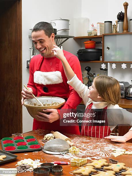 father and daughter making cookies - avental imagens e fotografias de stock