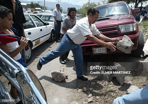 Tegucigalpa, HONDURAS: Un conductor de taxi coloca piedras para obstaculizar el paso de vehiculos por las principales avenidas de Tegucigalpa,...