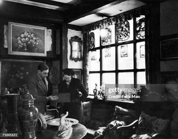 An antique dealer, with a customer in his antique shop on the corner of Charles Street and Waverton Street, Mayfair, 28 January 1939. Original...