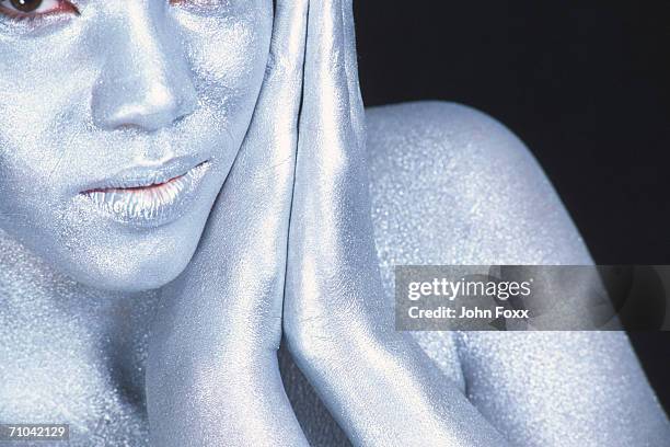 metallic woman hands on cheek - female body painting fotografías e imágenes de stock