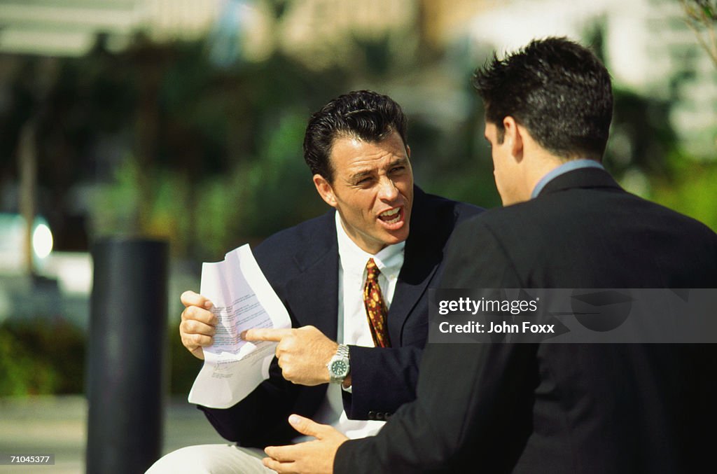 Businessman pointing at document and arguing