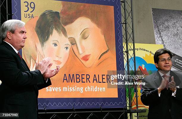 Attorney General Alberto Gonzales and Postmaster General John Potter of the U.S. Postal Service applaud after they unveiled the new AMBER Alert stamp...