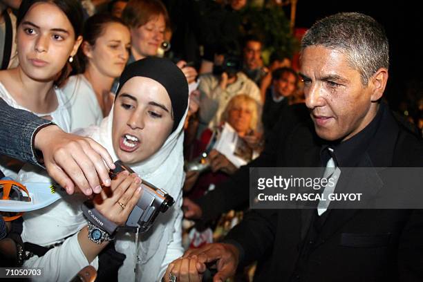 French actor Samy Naceri greets fans upon leaving the Festival Palace following the premiere of French director Rachid Bouchareb's film 'Indigenes'...