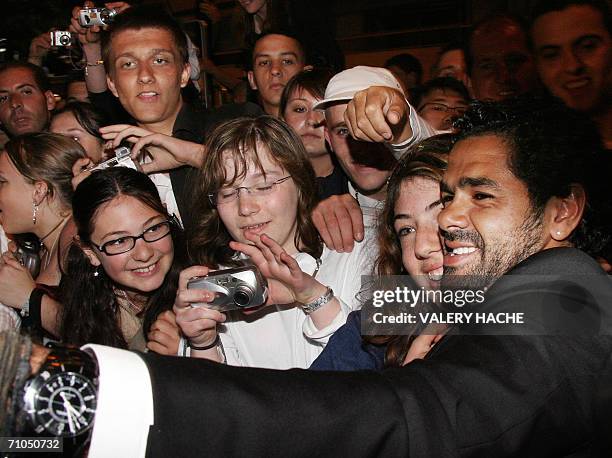 French actor Jamel Debbouze poses with a fan upon leaving the Festival Palace following the premiere of French director Rachid Bouchareb's film...