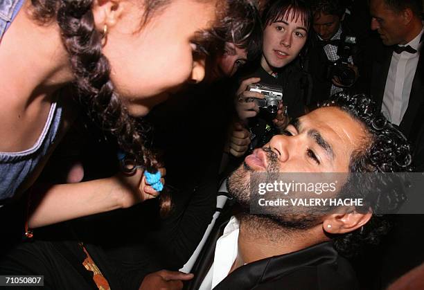 French actor Jamel Debbouze kisses a fan upon leaving the Festival Palace following the premiere of French director Rachid Bouchareb's film...