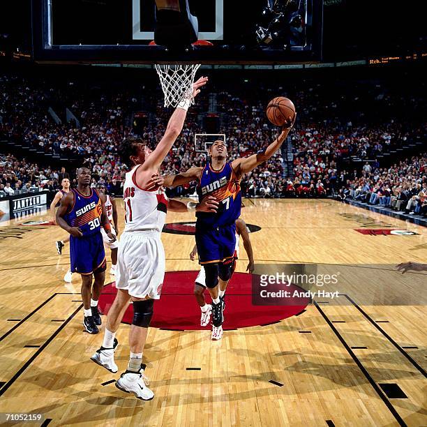 Kevin Johnson of the Phoenix Suns shoots a layup against Arvydas Sabonis of the Portland Trail Blazers at the Rose Garden on November 14, 1997 in...