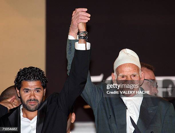 French actor Jamel Debbouze and a WWII veteran salute the crowd upon leaving the Festival Palace following the premiere of French director Rachid...