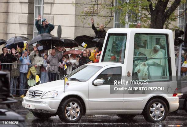 Pope Benedict XVI arrives escorted by Polish police under heavy rain on his popemobile at Warsaw's Pilsudski Square to celebrate a Holy Mass, 26 May...