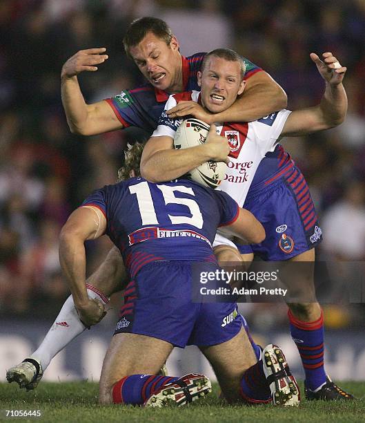 Ben Hornby of the Dragons gets tackled by the Newcastle defense during the round 12 NRL match between the Newcastle Knights and the St George...