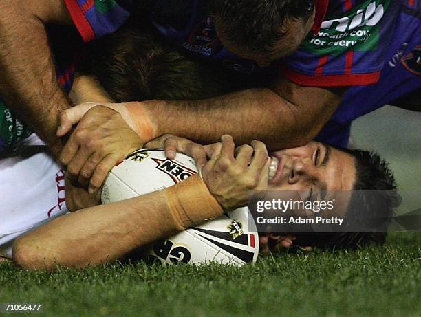 Trent Barrett of the Dragons is smashed during the round 12 NRL match between the Newcastle Knights and the St George Illawarra Dragons at Energy...