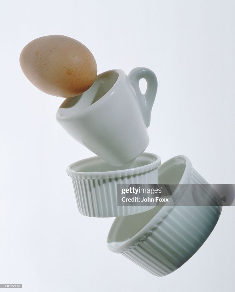 China cup and egg on white background, close-up