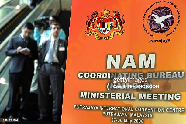 Delegates ride an escalator past a banner of the Non-Aligned Movement meeting of foreign ministers at International Convention Center in Putrajaya,...