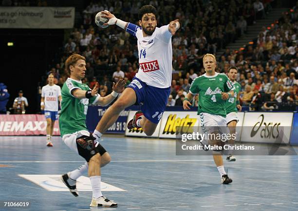 Bertrand Gille of HSV scores a goal against Andreas Simon and Arne Niemeyer of Minden during the Handball Bundesliga match between HSV Handball and...