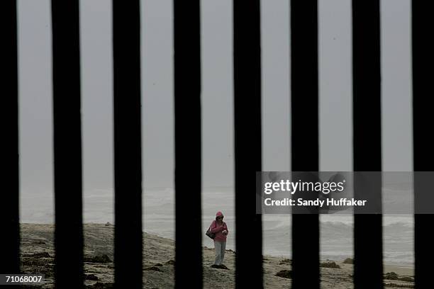 Mexican woman stands on the beach overlooking the U.S.-Mexico border wall on May 27, 2006 in San Ysidro, California. The senate approved a sweeping...