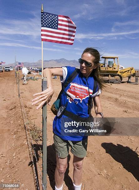 Jean Sawn, a volunteer of the Minuteman Civil Defense Corp., puts up American flags along new fence posts on May 27, 2006 in Palominas, Arizona. This...