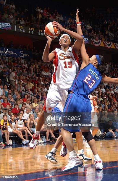 Asjha Jones of the Connecticut Sun goes to the basket against Plenette Pierson of the Detroit Shock at Mohegan Sun Arena on May 27, 2006 in...