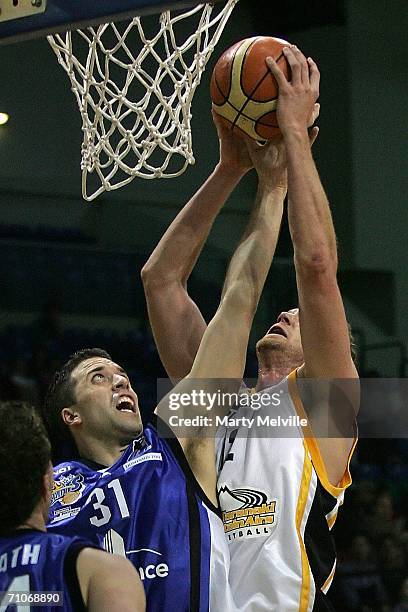 Tony Rampton of the Taranaki Mountain Airs aims for the basket past Chris Anderson of the Saints in defence during the round nine NBL match between...