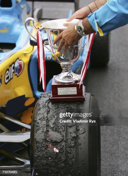 Team Principal Flavio Briatore of Renault places the Constructor's Trophy on the wheel of Fernando Alonso's racing car after winning the Monaco...