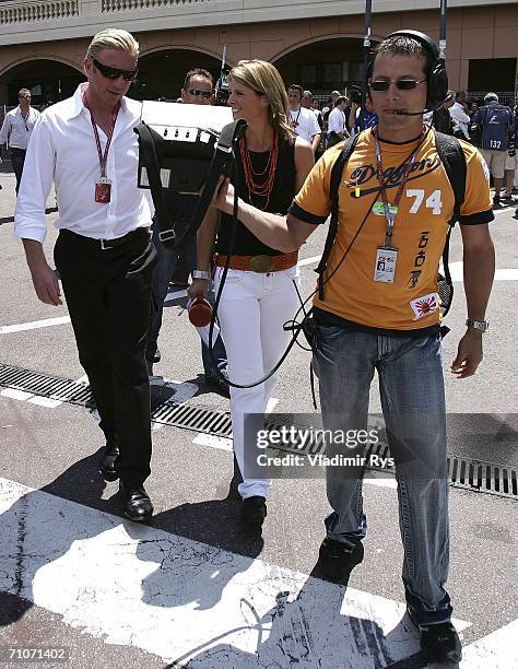 Former German tennis star Boris Becker walks with the commentator of a German television channel Premiere Maren Braun in the paddock prior to the...