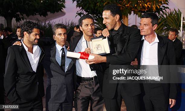 French actor Roschdy Zem celebrates during a photocall with fellow actors Bernard Blancan, Sami Bouajila and Jamel Debbouze nxt to director Rachid...