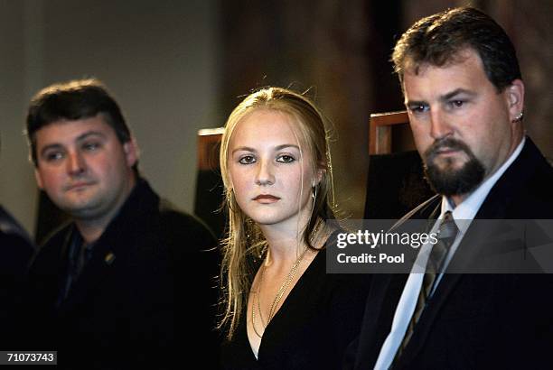 Australian miners Brant Webb and Todd Russell sit with Lauren Kielmann, the daughter of late miner Larry Knight, as they listen to speeches at a...