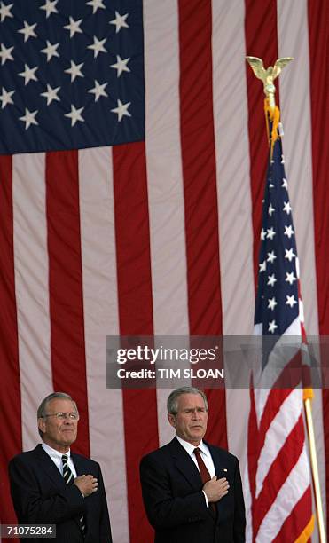 Arlington, UNITED STATES: US President George W. Bush listens to the playing of the National Anthem with Secretary of Defense Donald Rumsfeld during...