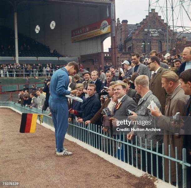 Wolfgang Weber signing autographs for German fans supporting their team at Villa Park during the group stages of the 1966 World Cup in England, July...