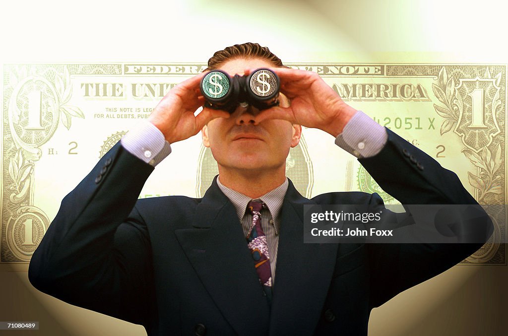 Businessman looking through binoculars